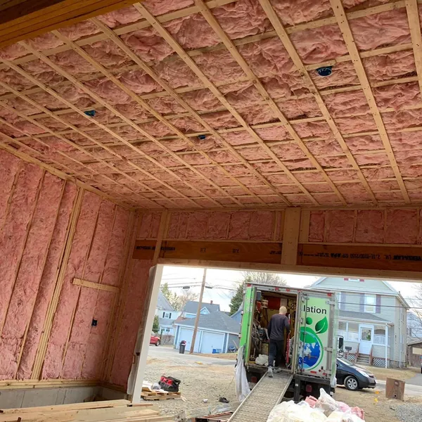 Fiberglass batt insulation installed by The Best Insulation, truck outside